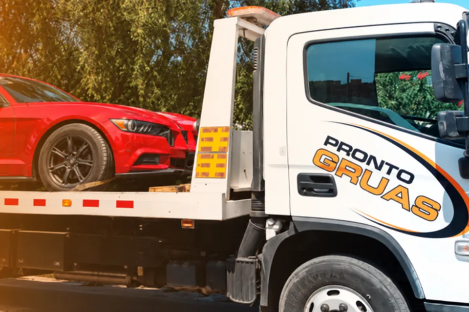 Grúa plataforma de Pronto Grúas trasladando un auto deportivo rojo