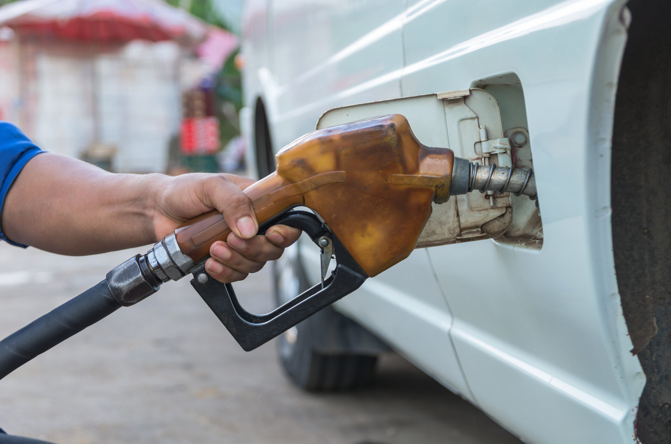 Hand hold Fuel nozzle to add fuel in car at filling station
